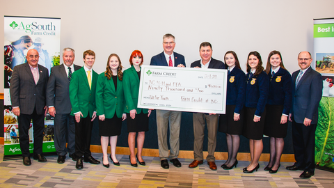 State 4-H Officers and State FFA Officers accept a Farm Credit check for $90,000 to NC 4‑H and FFA raised from Pull for Youth events across the state.