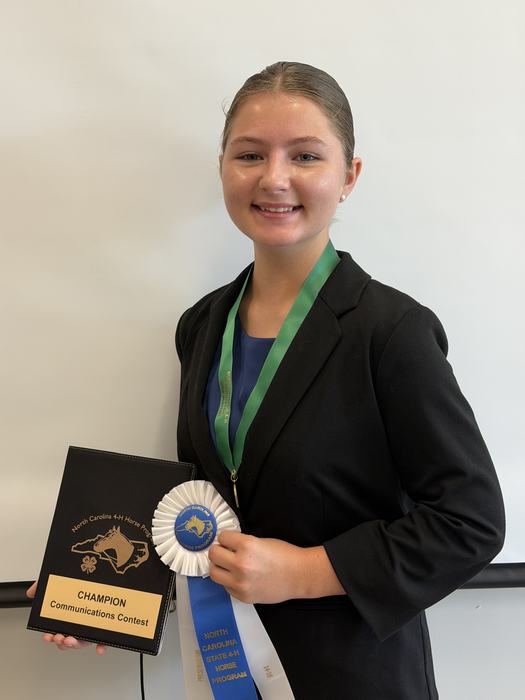 Rebekah Cieslak 14-18 Presentation Champion with her first place ribbon, medal and padfolio.