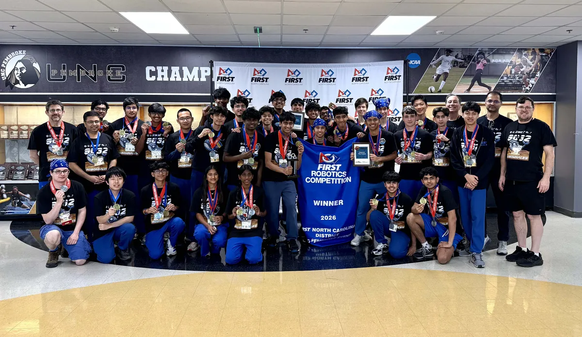 Robotics Team posing with First Robotics Competition 2026 Winner Banner