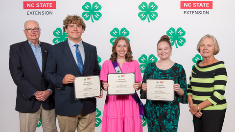Three recipients of the L.R. Harrill 4-H Scholarship pose together alongside two older adults