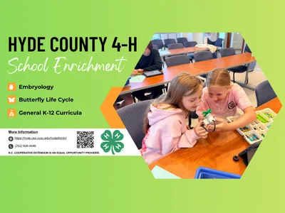 Two 4-H youth playing with robotics kits at a table.