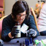 Peace sign, heart, sun and pictures of 4-H'ers on a tie-dye background