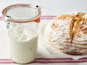 Picture of a jar of sourdough starter and a loaf of round bread