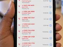A human hand holds an iPhone displaying a call history filled with suspected spam calls. Several entries show spoofed-looking phone numbers associated with northeastern North Carolina communities, including Ahoskie, Bear Grass, Roper, and Wind