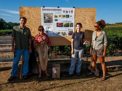 People standing beside poster at field day