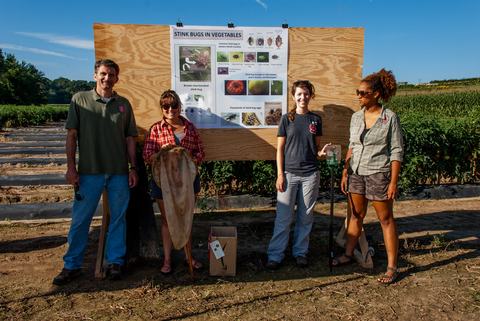People standing in front of poster at field day