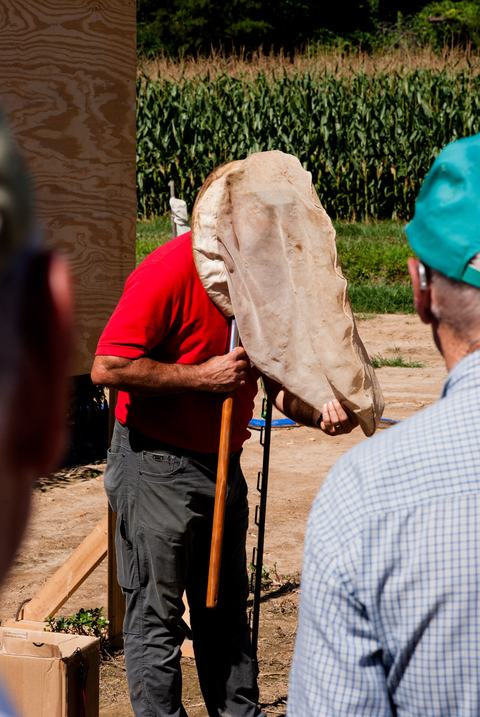 Man with insect net over head