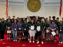 Large group 4-H'ers pose on a red-carpeted chamber floor in the state legislative building as part of a tour during 4-H Congress.