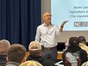 Wayne Buhler holding an object in his hand while teaching.