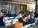 A group of professionals sitting in a room listening to four panelists speak.