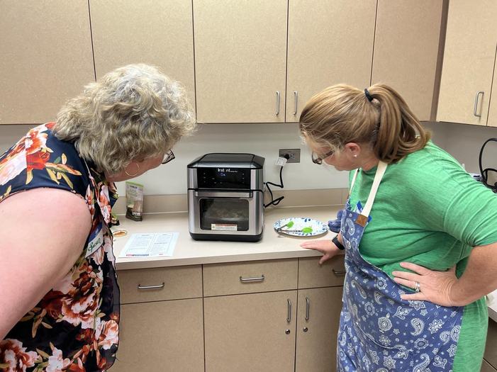 two participants looking at air fryer