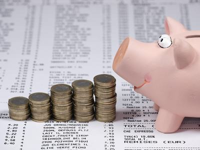 Piggy Bank is facing toward five rows of coins stacked on top of grocery receipts.