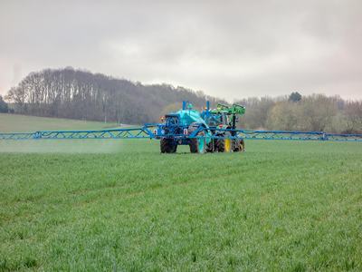 tractor spraying crops in a field