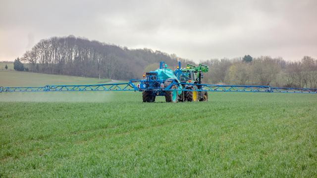 tractor spraying crops in a field