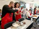 Picture of a man and woman looking at a recipe and cooking.
