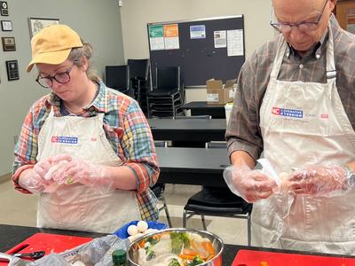 Two N.C. Cooperative Extension volunteers prepare food together during a hands-on cooking activity.