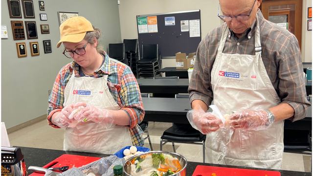Two N.C. Cooperative Extension volunteers prepare food together during a hands-on cooking activity.