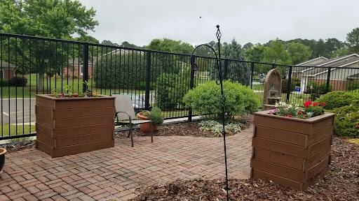 A gated courtyard has wide paths and raised beds
