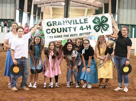 granville county 4h group posing at an event holding up a banner dressed in 50s clothing