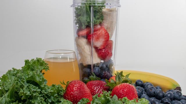 Smoothie fruits and vegetables in and around a blender.  Ingredients for a smoothie.