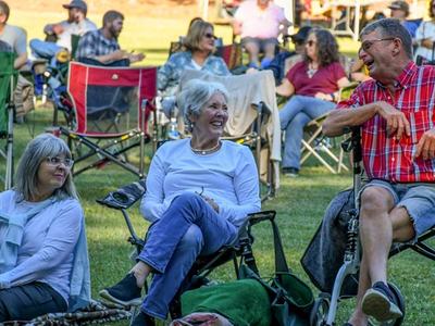 group laughing, sittting in lawnchairs on lawn