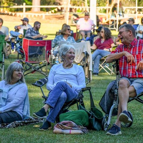 group laughing, sittting in lawnchairs on lawn