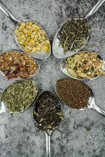 Seven spoons each contain a different tea herb.