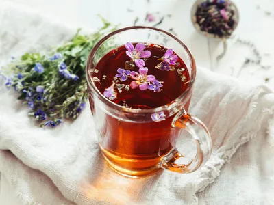 Floral herbs float in a cup of tea.