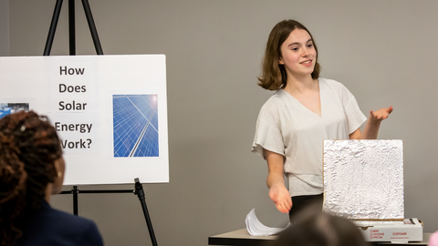4-H member doing a presentation on how solar energy works to an audience.