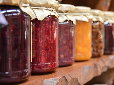Glass jars of canned jams and jellies on a shelf