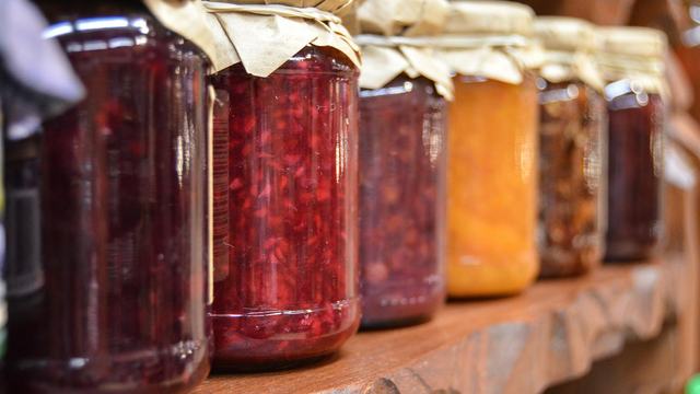 Glass jars of canned jams and jellies on a shelf