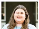 Summer N.C. State intern Katelyn Medlin smiles while standing outside a building.