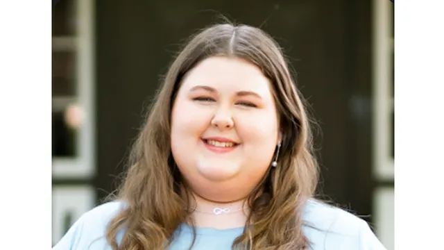 Summer N.C. State intern Katelyn Medlin smiles while standing outside a building.