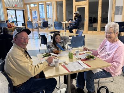 A happy couple eating at our caswell Community soup luncheon with their granddaughter.