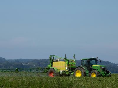 a tractor spraying pesticides on a field