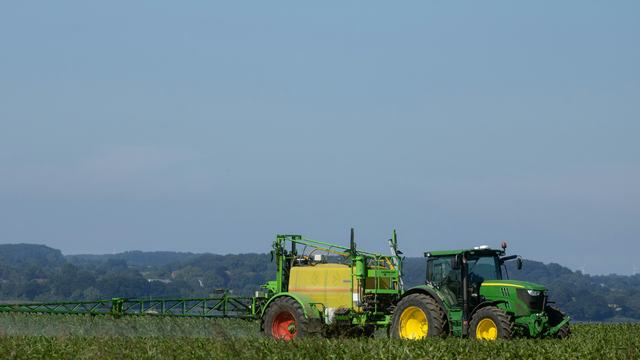 a tractor spraying pesticides on a field