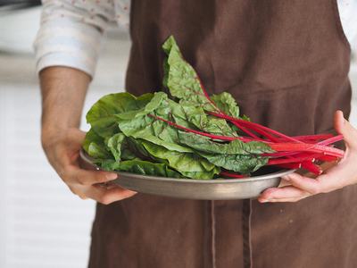 Person holding plate of swiss chard