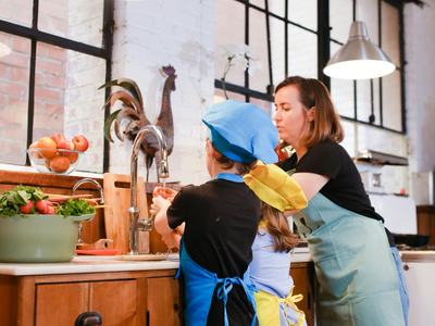 A mom and her kids enjoying a cooking session in a stylish industrial kitchen.