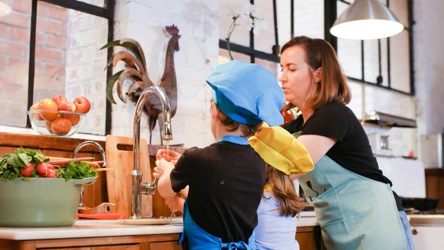 A mom and her kids enjoying a cooking session in a stylish industrial kitchen.