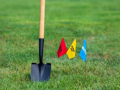 Picture of shovel in grass with marking flags