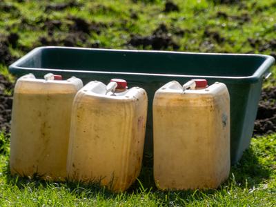 plastic pesticide containers sitting in green grass