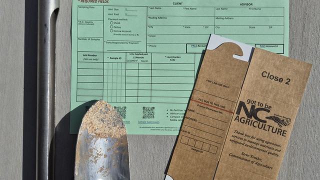 a photograph of a soil test, accompanying paper form, a soil corer, and a trowel