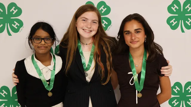 Three 4-H members wearing medals pose for a photo after being recognized during the 2026 North Carolina 4-H State Presentation Finals.