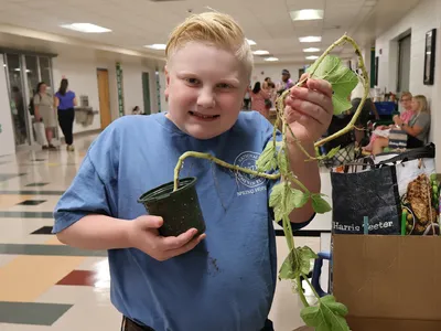 A 4-H member holds an uprooted plant for his horticulture-related presentation during the 2026 North Carolina 4-H State Presentation Finals.