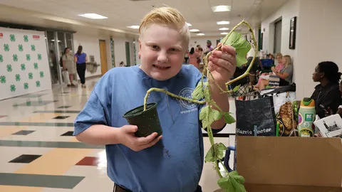 A 4-H member holds an uprooted plant for his horticulture-related presentation during the 2026 North Carolina 4-H State Presentation Finals.