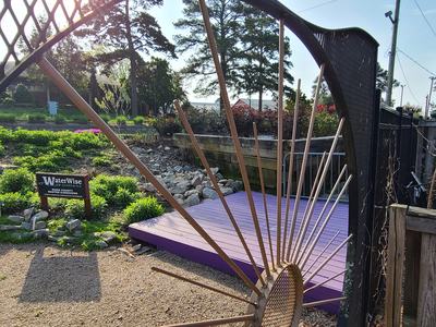 A garden next to a gravel walkway and purple stage