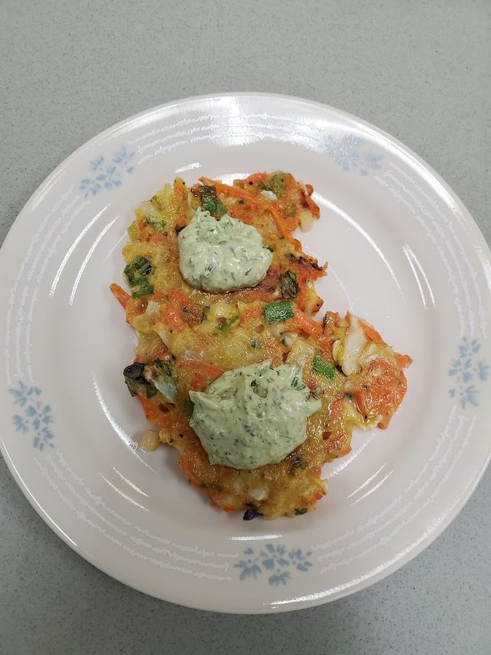 Pancakes made from shredded vegetables topped with an a creamy herb sauce.