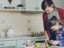 Adult and child preparing food together in a  home kitchen setting