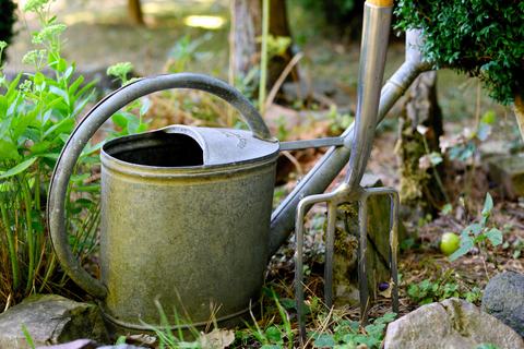 watering can and pitchfork in the garden