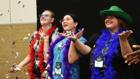 Three 4-H members smile and reach up as confetti falls, as part of a workshop at 4-H Congress.
